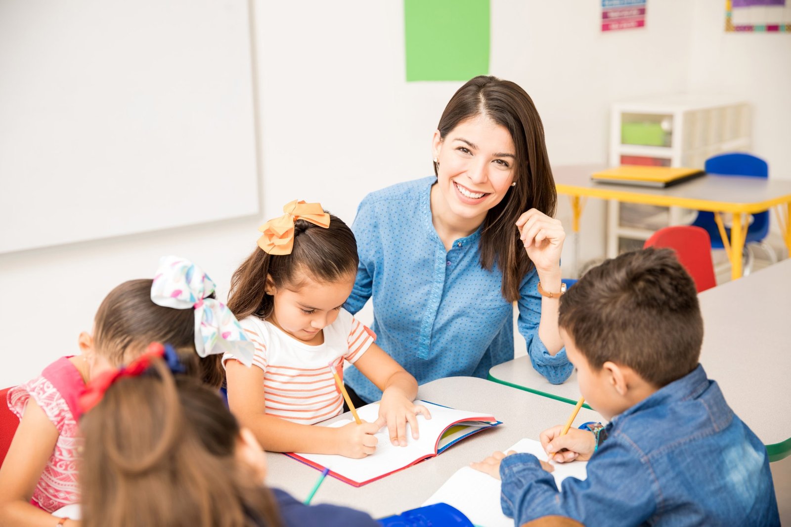 portrait-gorgeous-hispanic-preschool-teacher-teaching-her-students-classroom-scaled-1.jpg